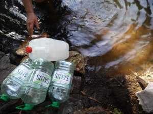 Vecinos de Pan de Azúcar recogen agua de arroyos cercanos para usos elementales.